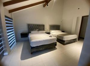 une chambre avec deux lits et une fenêtre dans l'établissement Hostal Independencia, à Santa Cruz de la Sierra