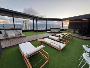 a patio with lounge chairs and tables on a building at Original Studio ESCALANTE in San José