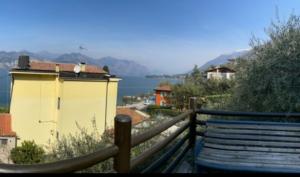 a bench next to a fence with a view of the water at Casa Azzurra in Malcesine