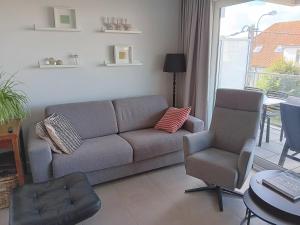 a living room with a couch and a chair at Zilt 0202 in Westende +13 photos