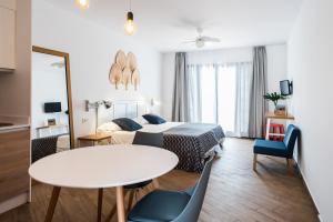 a living room with a bed and a table and chairs at Los Cardones Boutique Village in Playa de las Americas