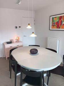 a dining room with a white table and chairs at Zilt 0202 in Westende