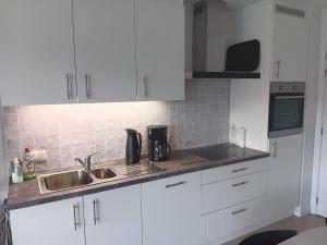 a kitchen with white cabinets and a sink at Zilt 0202 in Westende
