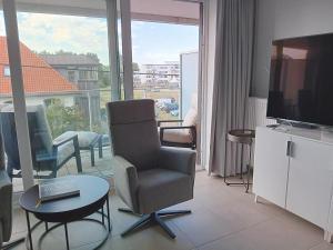 a living room with a chair and a television at Zilt 0202 in Westende