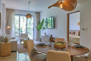 a dining room and living room with a table and chairs at Modern Escape with Pool & Beach in Puerto Plata