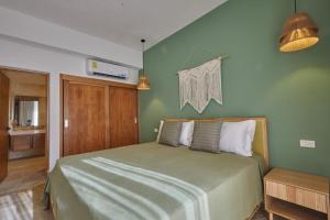 a bedroom with a bed with a green wall at Modern Escape with Pool & Beach in Puerto Plata +13 photos
