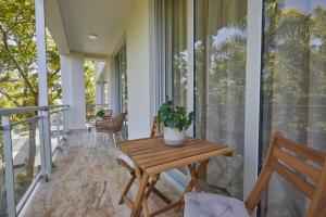 a porch with a wooden table and a potted plant at Modern Escape with Pool & Beach in Puerto Plata