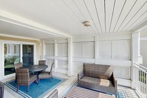 ein Esszimmer mit Tisch und Stühlen und Fenstern in der Unterkunft 2925 Atrium in Seabrook Island