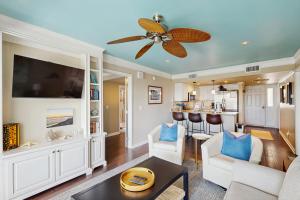 ein Wohnzimmer mit Deckenventilator und eine Küche in der Unterkunft 2925 Atrium in Seabrook Island