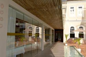 a building with glass windows and a swimming pool at Zank by Toque Hotel in Salvador