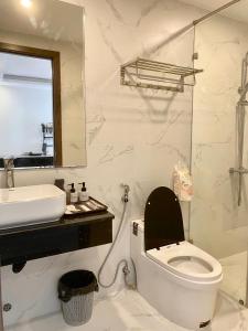 a white bathroom with a toilet and a sink at COCO Villa 6 Apartment & Hotel in Da Nang