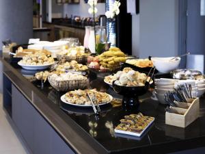 a buffet with many different types of food on a table at ibis Botucatu in Botucatu