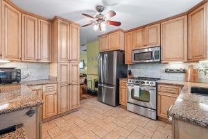 a kitchen with wooden cabinets and stainless steel appliances at Downtown Gem- Dog Friendly Walk to Everything in St. Augustine