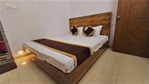 a bedroom with a large bed with a wooden headboard at Balaji Lodging in Pandharpur
