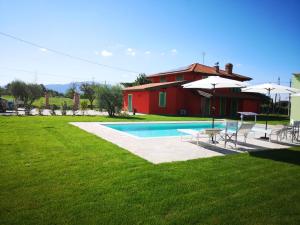 a house with a swimming pool with chairs and umbrellas at Villa Benedetti in Galleno