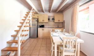 een keuken met een trap en een tafel en stoelen bij Sueño al Mar Residence & Hotel in Potrero