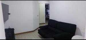 a living room with a black couch and a door at Apartamento VIP Caracas in Caracas