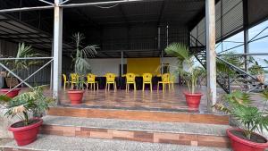 a group of yellow chairs and tables in a building at Tiger Wilderness Lodge, Tadoba in Chimur
