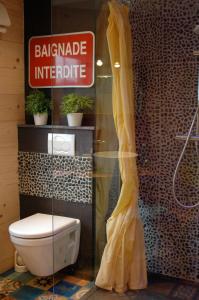 a bathroom with a toilet and a sign on the wall at La Souricière in Silenrieux