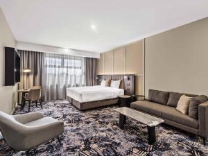 a hotel room with a bed and a couch at Mercure Pakenham in Pakenham +35 photos