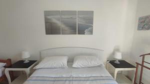 a bedroom with a bed with two nightstands and two lamps at Casa del Ferroviere in Letojanni +6 photos
