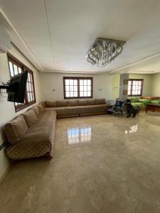 una gran sala de estar con sofás y TV de pantalla plana. en Ferme Erraha, en Bhalil