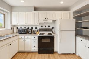 Una cocina con gabinetes blancos y un refrigerador blanco. en Atlanta Center City Stay Walk Everywhere, en Atlanta