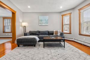 een woonkamer met een bank en een salontafel bij Tufts 2 Bed & Office - Free Parking in Medford