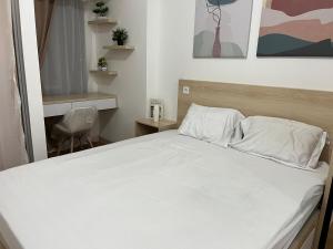 PumpangsinengにあるCozy Loft - the place you will always come back toの寝室にある白いシーツと枕が置かれたベッド