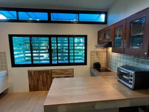 een keuken met een aanrecht in een kamer met ramen bij The Wild Villa Phuket Rawai in Nai Harn Beach