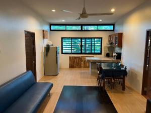 een woonkamer met een blauwe bank en een keuken bij The Wild Villa Phuket Rawai in Nai Harn Beach