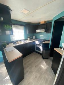 a kitchen with blue walls and a counter top at Lisa caravan hire in Skegness
