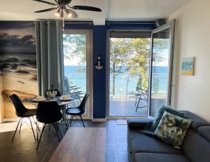 a living room with a couch and a table with chairs at Baltic Crown - Premium Sea View Rewal in Rewal