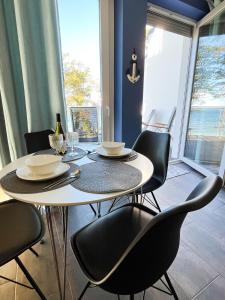 a dining room table with black chairs and a table and a table and chairsktop at Baltic Crown - Premium Sea View Rewal in Rewal +7 photos