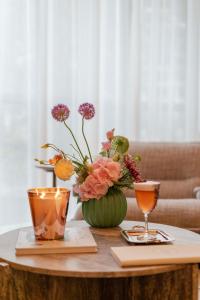 a table with a vase of flowers and two glasses at Suites By Le Rêve in Tangier