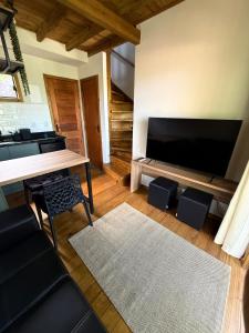 un salon avec une grande télévision à écran plat dans l'établissement Refúgio Sambaqui, à Florianópolis