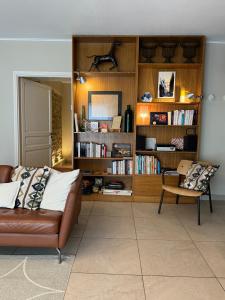a living room with a couch and a book shelf at Le Hameau du Buron - "Le Petit Buron" - Option SPA in Eyzin-Pinet