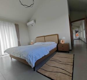 マエブールにあるLes Champs Beau Vallonのベッドルーム1室(大型ベッド1台、青い掛け布団付)