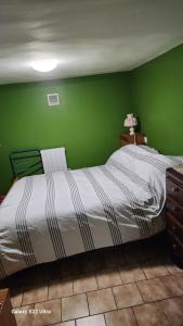 una camera da letto verde con un letto e una parete verde di Wauquier a Mons-en-Baroeul