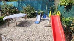 un parco giochi con tre attrezzature da gioco in un giardino di Wauquier a Mons-en-Baroeul