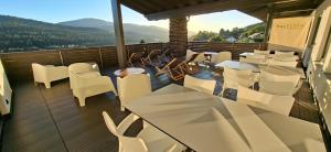 balcone con tavoli e sedie bianchi e vista di BayVista, die Bayerwald Lodge a Lam