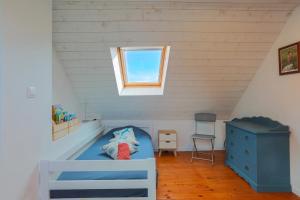 a bedroom with a blue bed in a attic at Charmante maison à Pleubian in Pleubian