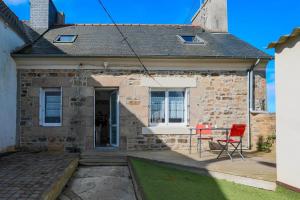 a brick house with a table and chairs on a patio at Charmante maison à Pleubian in Pleubian