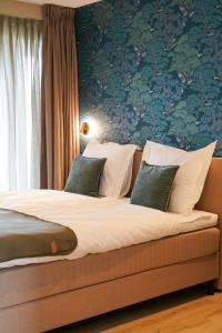 1 dormitorio con 1 cama con sábanas blancas y papel pintado verde en Landgoed Erve Triesthaar, en De Lutte