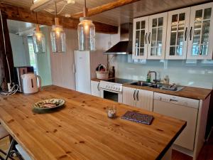 a kitchen with a wooden counter top and a wooden table at Arthur Brygga Nyksund in Nyksund