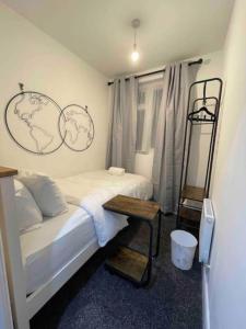 ein Schlafzimmer mit einem Bett mit zwei Karten an der Wand in der Unterkunft 4 Bedroom Terraced House with Huge Garden in Pinner