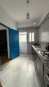 a kitchen with a blue door and a counter at Fairly new one bedroom guest house in Ariana