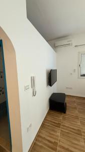 a room with a black chair in a white wall at Fairly new one bedroom guest house in Ariana