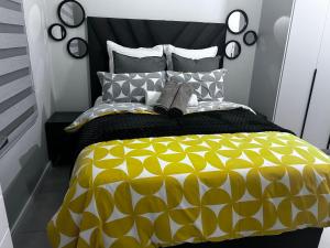 a bedroom with a bed with a yellow and black comforter at The Blyde blue lagoon in Pretoria +36 photos