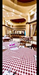 Cozy Family 3 BR apartment by the sea في مرسى علم: مطعم به طاولات وكراسي وأرضية مربعة